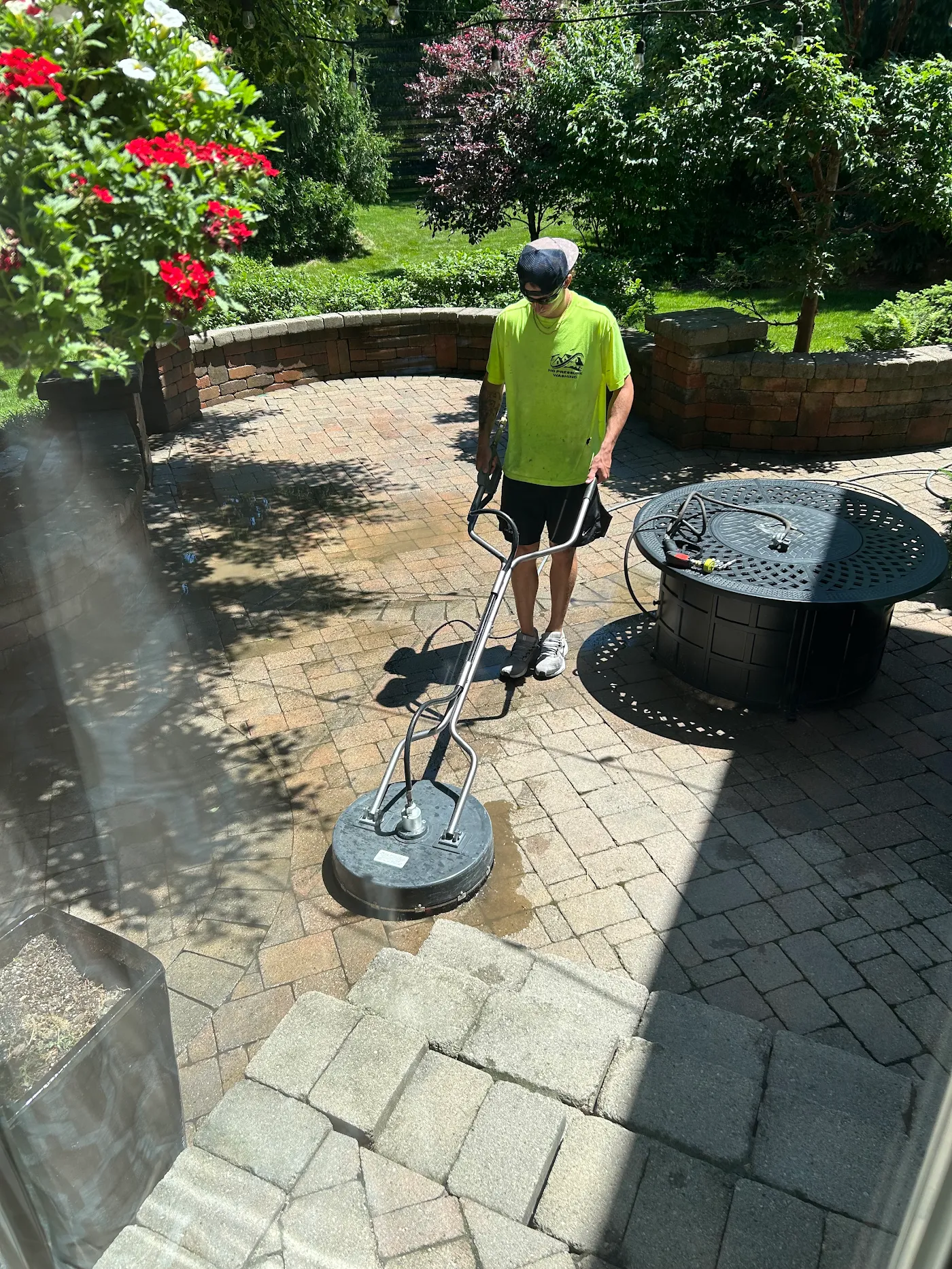 HG technician running a surface cleaner across the paver patio
