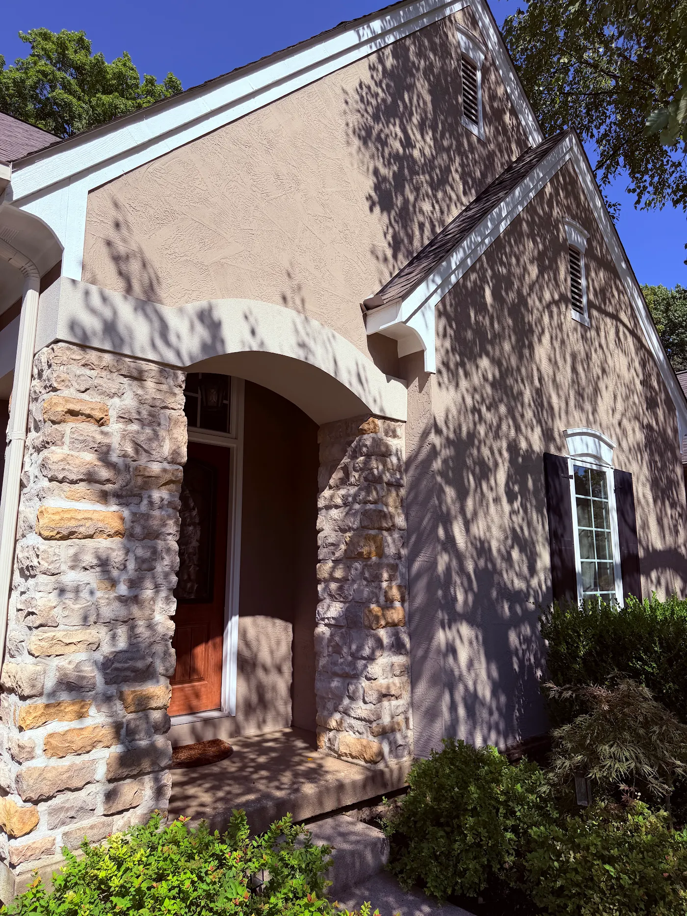 Stone and stucco entry of a home after an HG soft wash