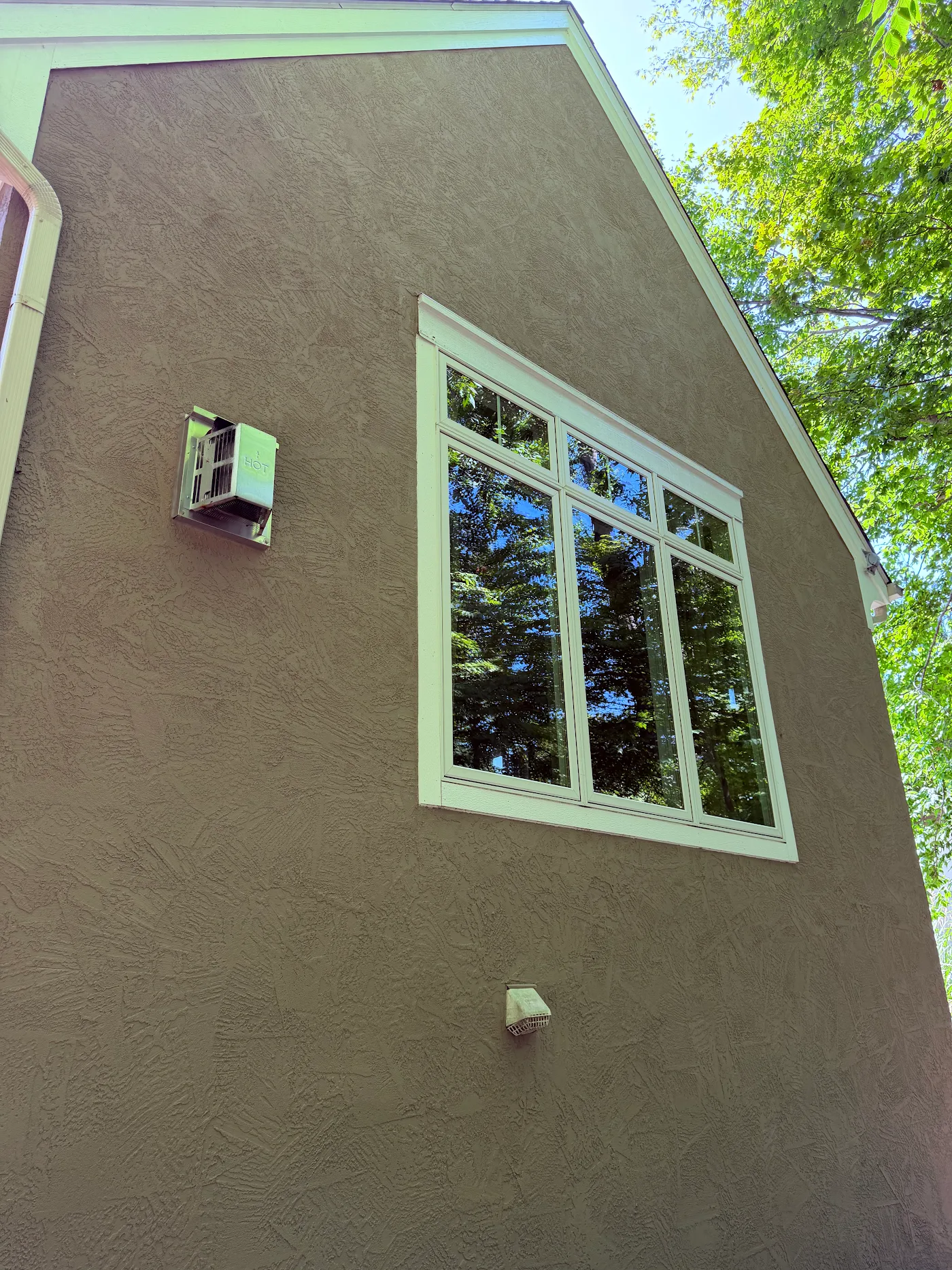 Tall stucco gable wall with clean windows