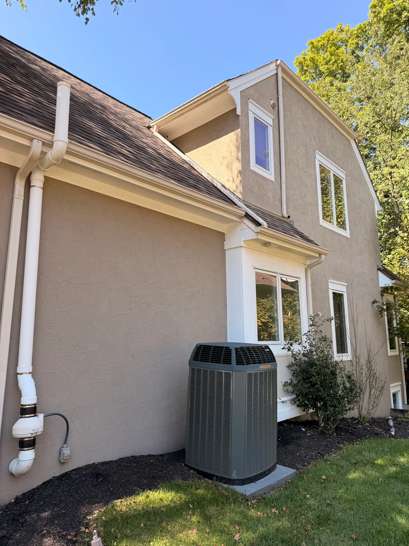 Freshly soft-washed tan stucco home with white trim
